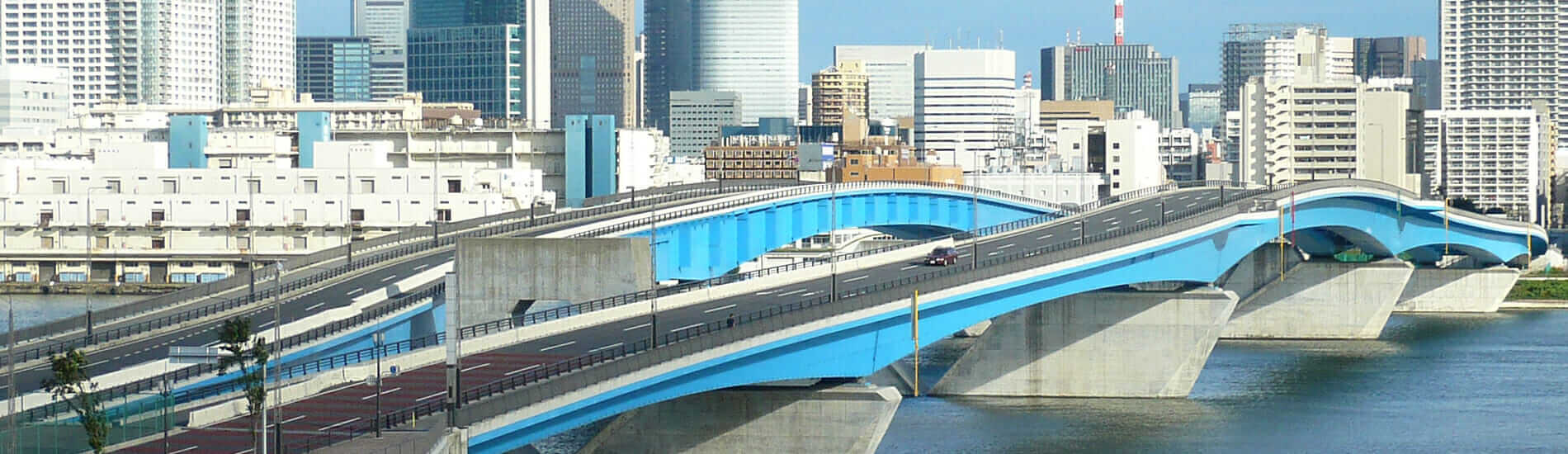 Urban skyline with blue highway bridge crossing river
