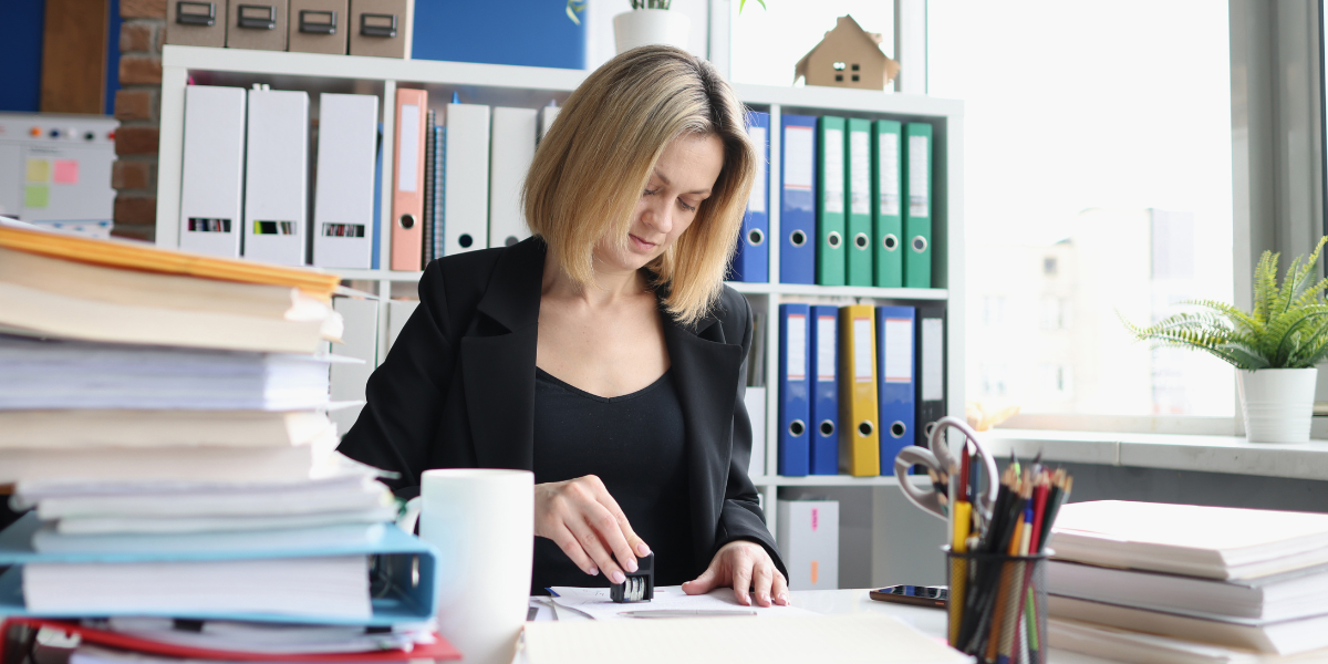 Law clerk organizing case files and legal documents at office desk demonstrating daily tasks of legal administrative work