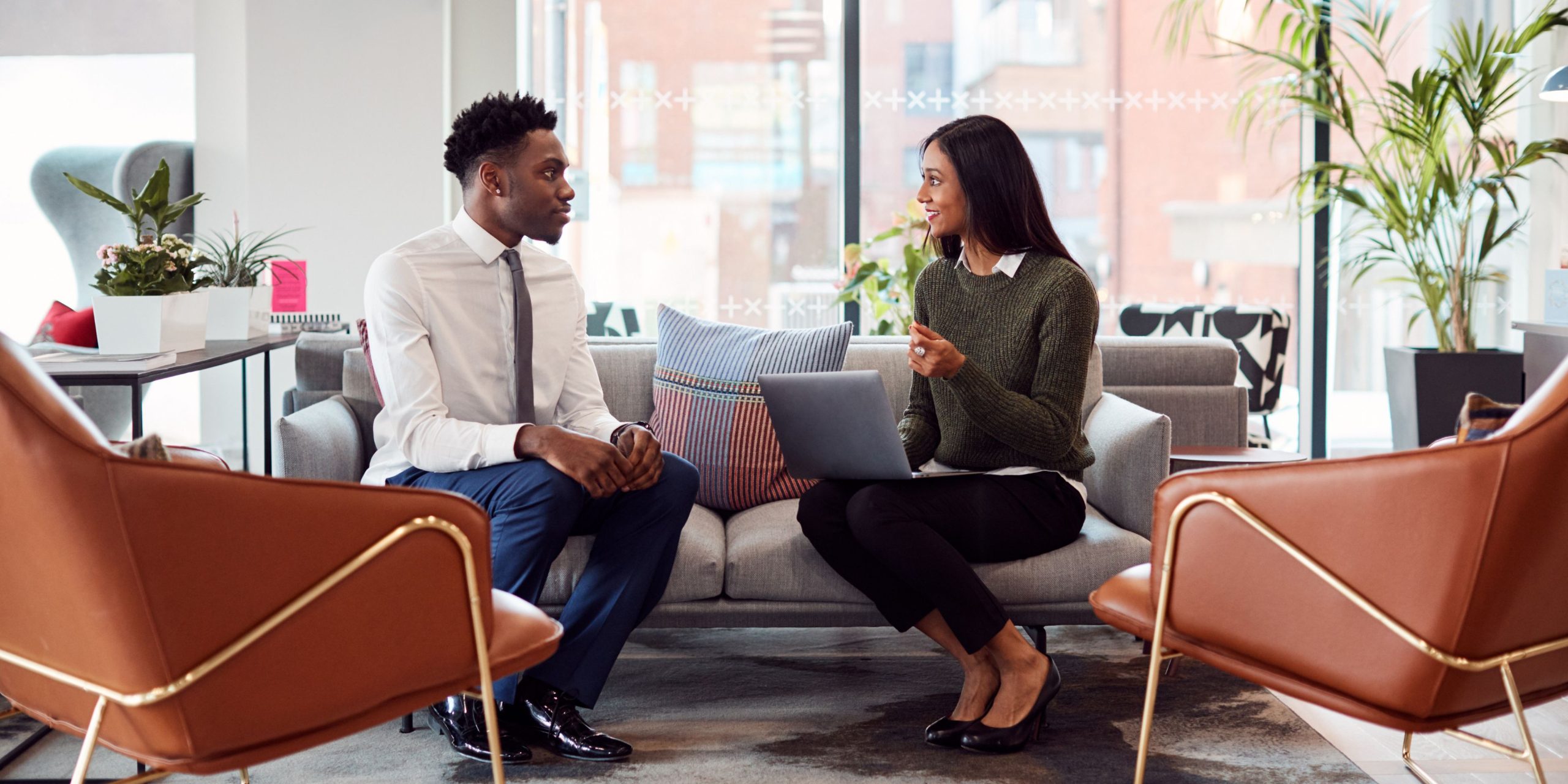 A candidate confidently discussing skills and achievements with an interviewer, using prepared notes.