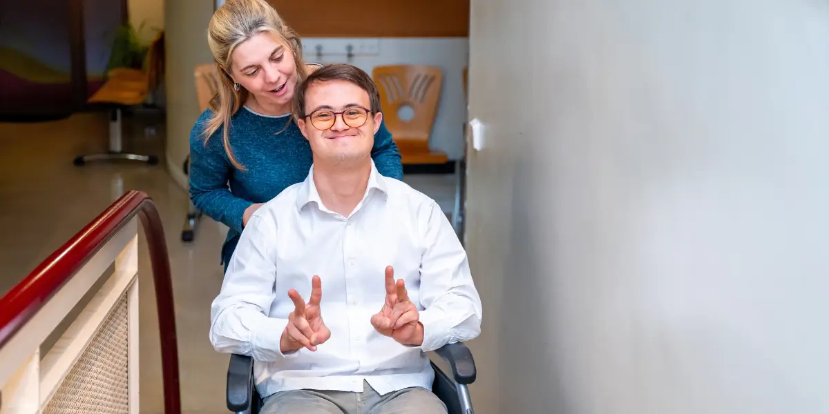 A caring community support worker providing assistance to a special needs person, highlighting the rewarding nature of a community support services career.