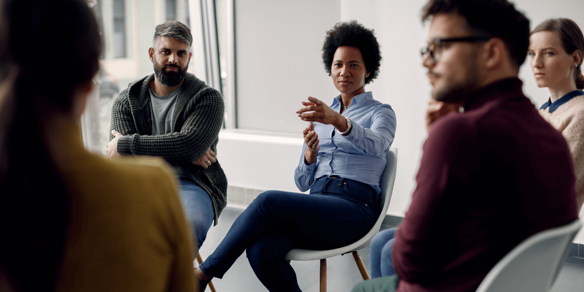 A skilled community support worker leading a group therapy session, emphasizing the collaborative roles within a community support services career.