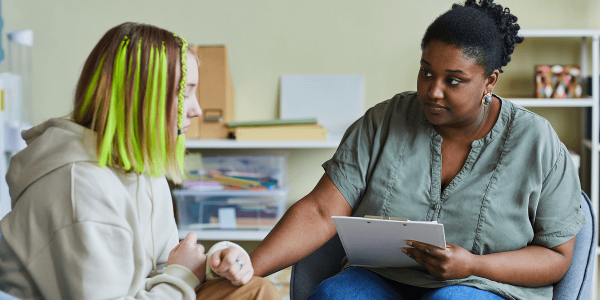 A dedicated community support worker helping a young person during a stressful time, highlighting the impact of a community support services career.