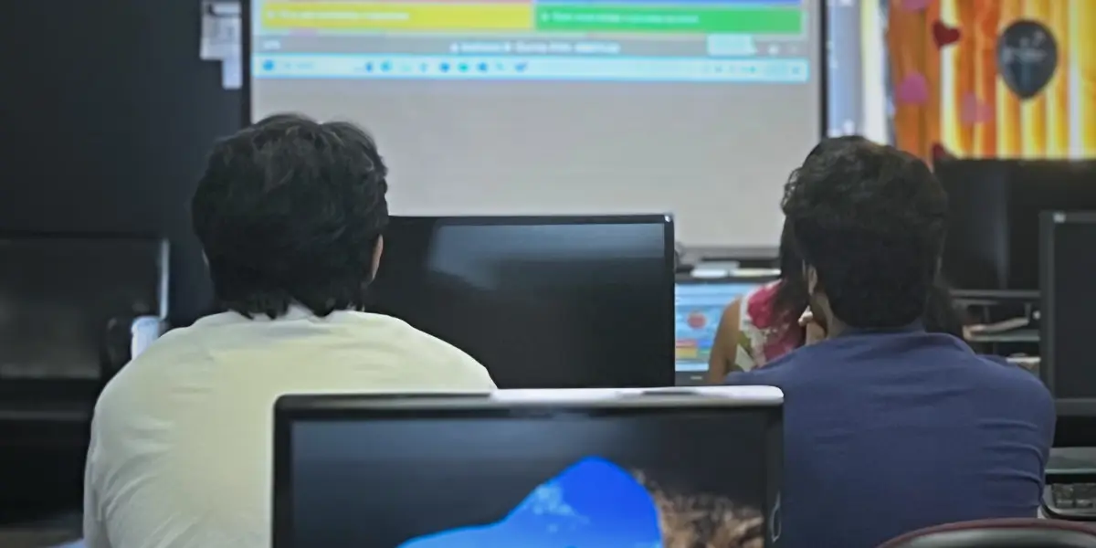 Web development students at Academy of Learning Career College working on front-end coding projects.