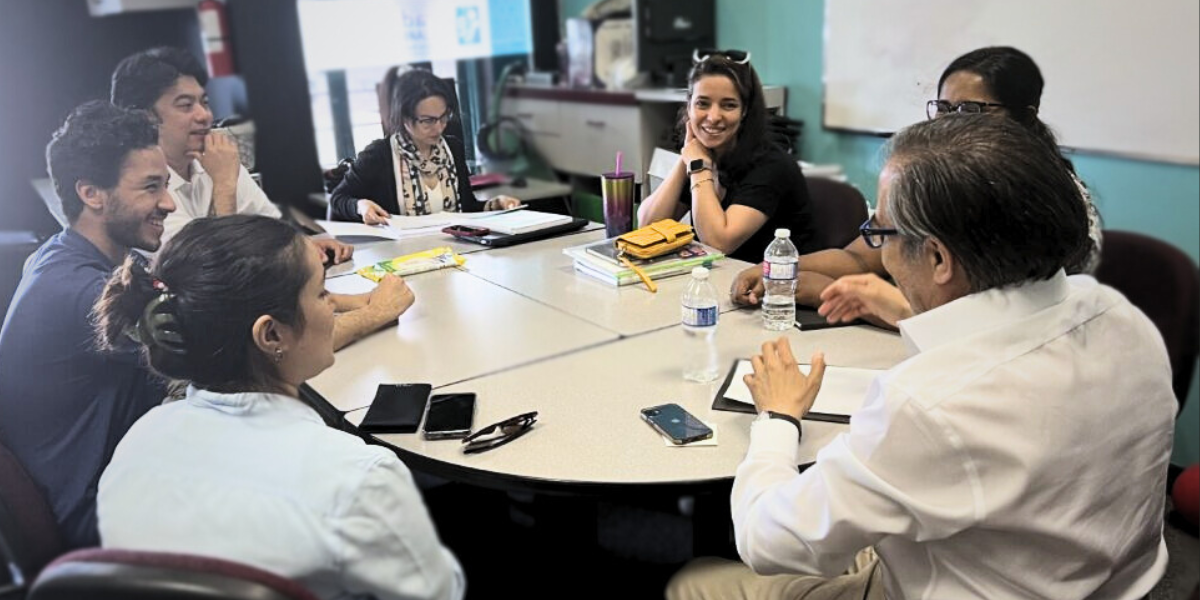 A group of adult students engaged in a collaborative discussion at Academy of Learning Career College, illustrating peer-to-peer teaching—a key method for retaining new skills and knowledge.