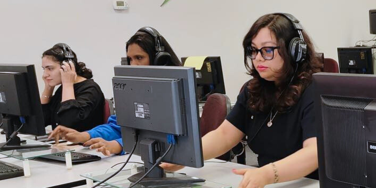 Future web developers receiving instructor support at Academy of Learning Career College.