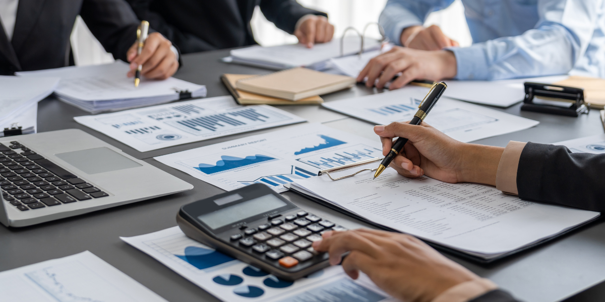 Team of accounting professionals collaborating on financial reports and analysis - demonstrating the teamwork environment in entry-level accounting jobs Canada offers through non-university career paths and accounting diploma programs.
