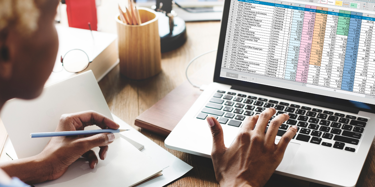 jobseekers with MOS certifications Person reviewing detailed financial spreadsheet in Microsoft Excel showing color-coded data analysis for business accounting, demonstrating Excel's powerful data management capabilities.