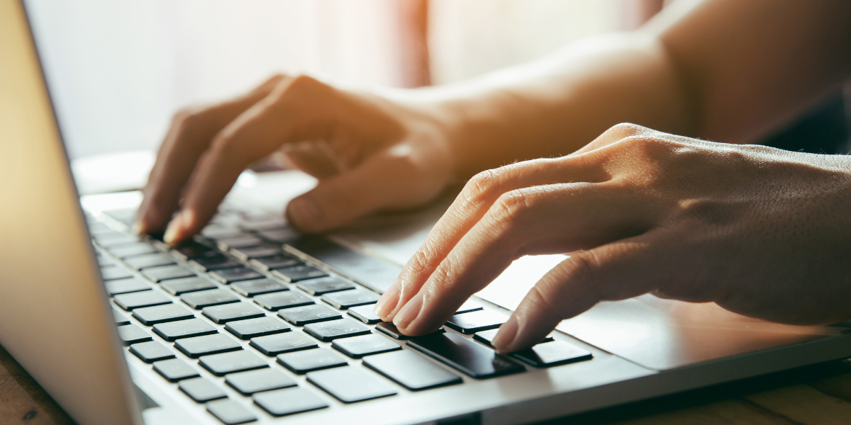 Close-up view of hands practicing touch typing on laptop keyboard, essential for improving typing skills and passing online typing speed tests free of charge.